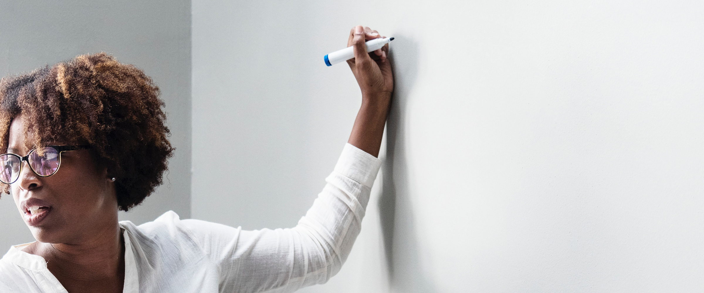 female teacher writing on whiteboard